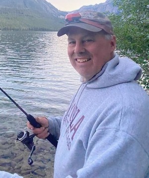 person wearing a gray hat and hoodie holding a fishing rod